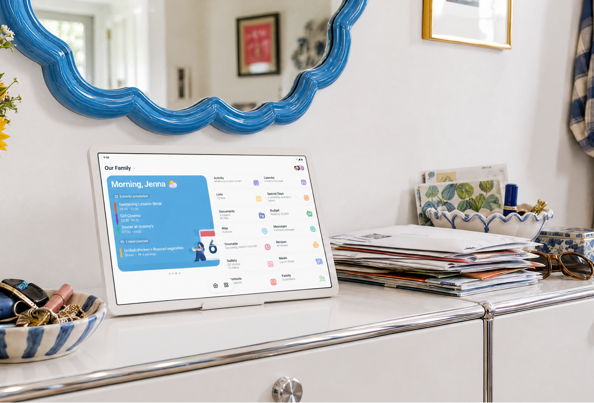 Home Hub on a hallway console below a blue mirror, showing the family home screen beside the day's mail